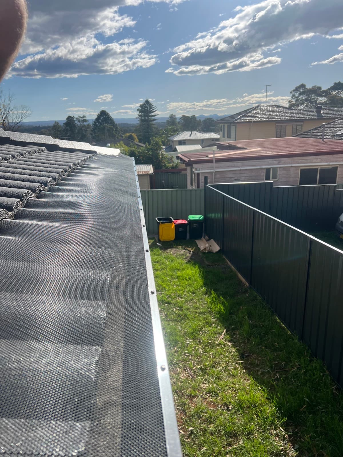 New aluminium gutter guard mesh installed along a tiled roof edge